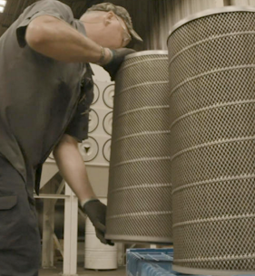 Machine operator changing out the replacement dust collector cartridge filters in a collection system.